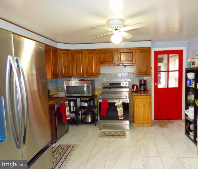 kitchen with appliances with stainless steel finishes, decorative backsplash, and ceiling fan