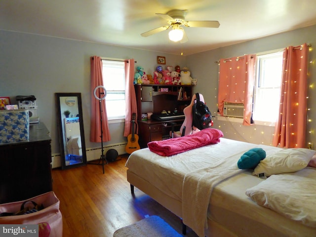 bedroom featuring hardwood / wood-style floors, ceiling fan, and baseboard heating