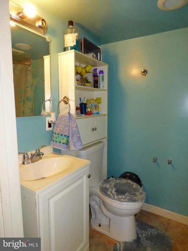 bathroom featuring vanity, toilet, and tile patterned flooring