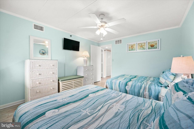 bedroom featuring light wood-type flooring, ceiling fan, and crown molding