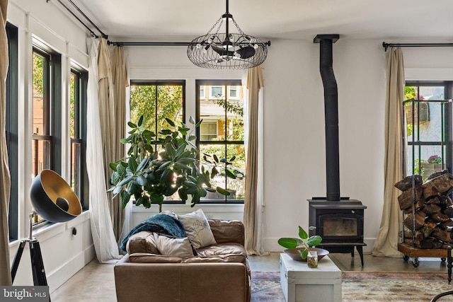 living area with a wood stove and a chandelier