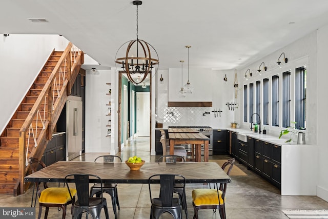 dining area featuring concrete floors, a notable chandelier, and sink