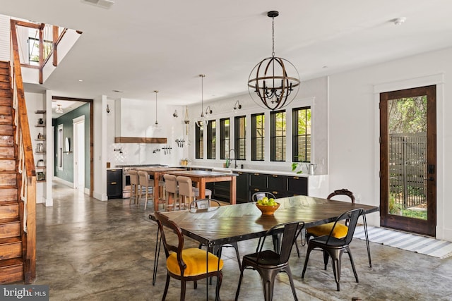 dining room featuring a wealth of natural light, sink, and an inviting chandelier