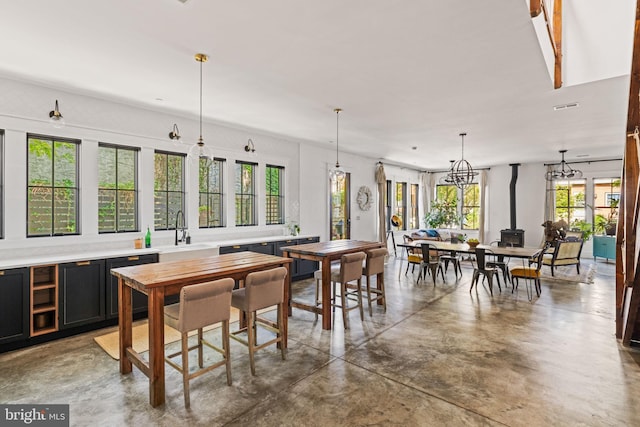 dining space with a healthy amount of sunlight, sink, and a wood stove