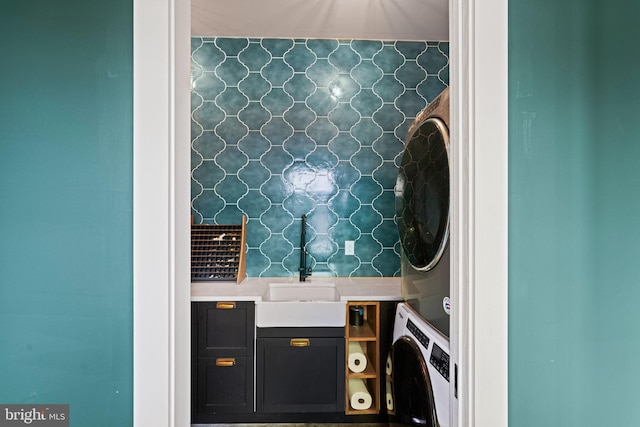 interior space featuring stacked washing maching and dryer, vanity, and decorative backsplash