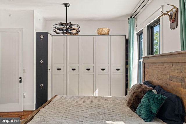 bedroom with hardwood / wood-style floors and a notable chandelier