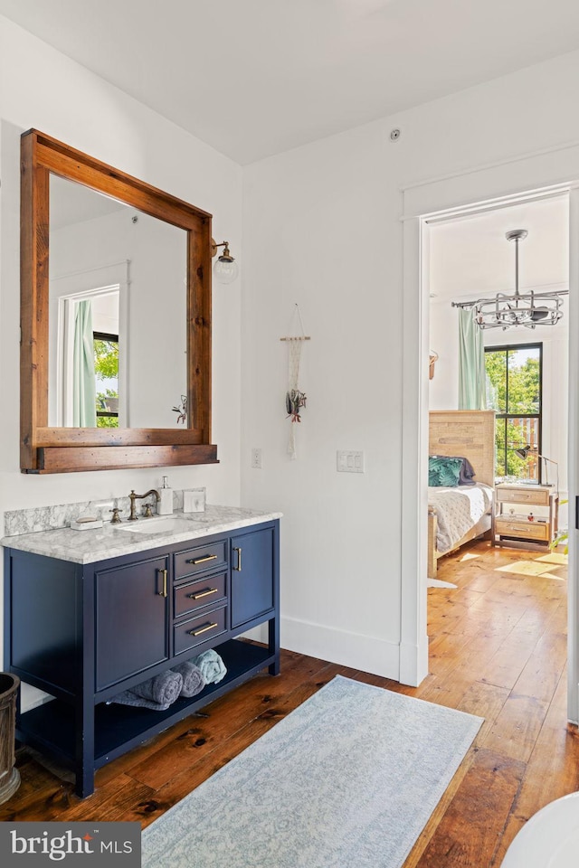 bathroom featuring wood-type flooring, a chandelier, and vanity