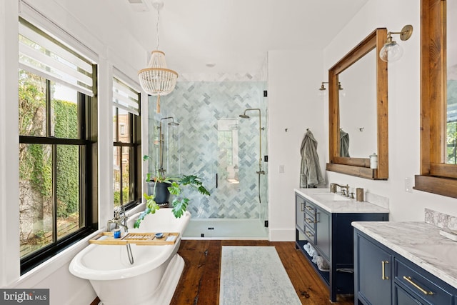 bathroom with vanity, an inviting chandelier, independent shower and bath, and wood-type flooring