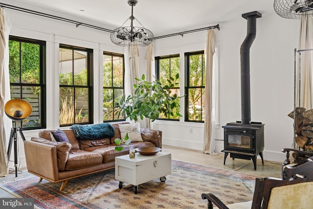 living room featuring a wood stove and a chandelier