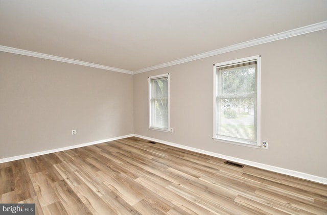 spare room with light hardwood / wood-style flooring and crown molding