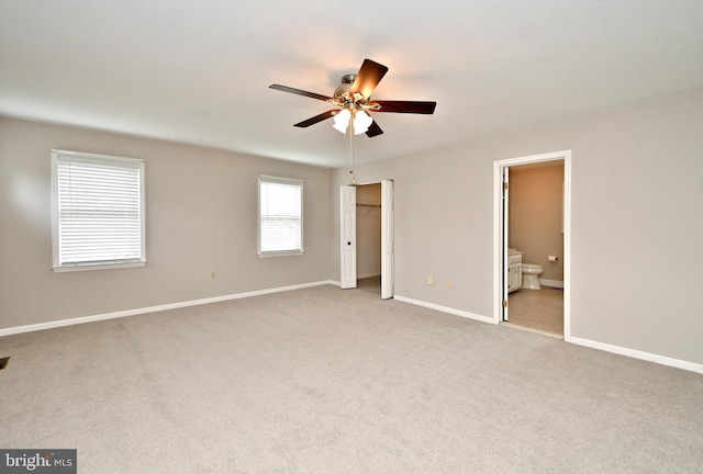 unfurnished bedroom featuring connected bathroom, ceiling fan, and light colored carpet