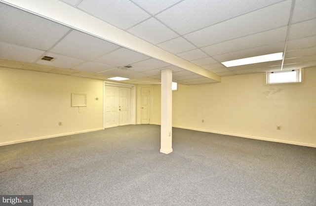 basement featuring carpet floors and a paneled ceiling