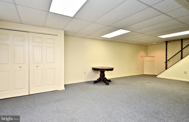 basement with a drop ceiling and carpet