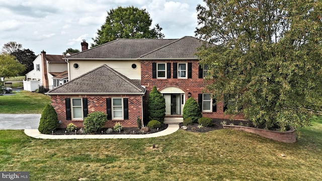 colonial home featuring a garage and a front lawn