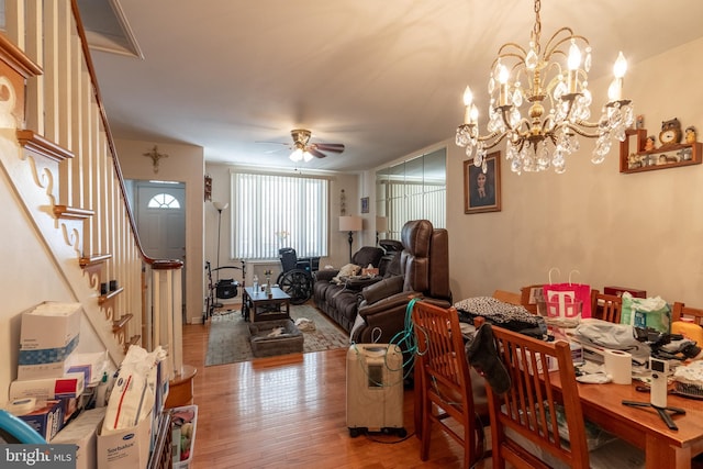 dining area with hardwood / wood-style floors and ceiling fan with notable chandelier