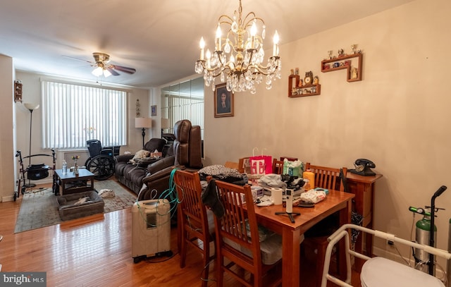 dining area featuring hardwood / wood-style floors and ceiling fan with notable chandelier