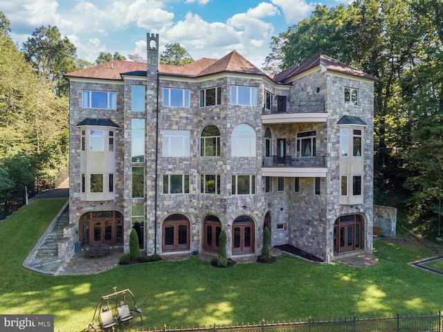 view of front of house with a front lawn and a balcony