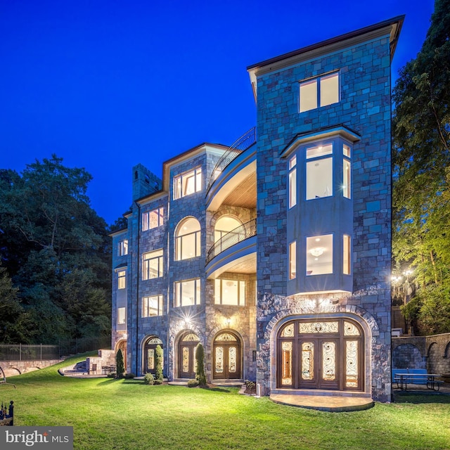 view of front of property featuring french doors and a lawn