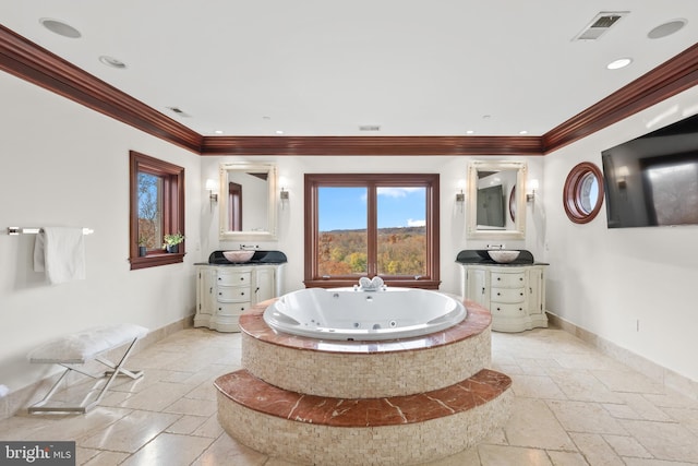 bathroom with tiled bath, vanity, and crown molding