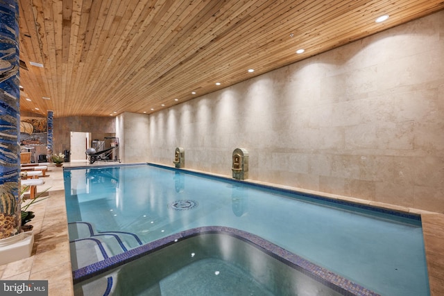 view of swimming pool with an indoor hot tub