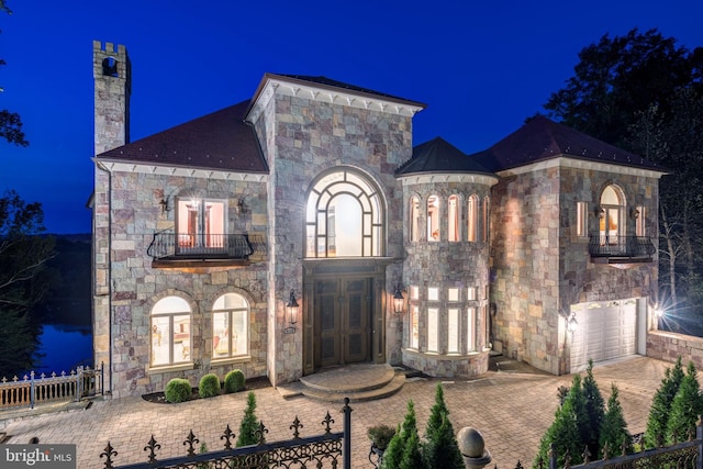 view of front of home featuring a garage, french doors, and a balcony