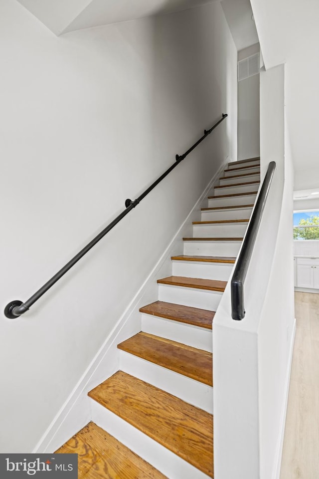 staircase with wood-type flooring