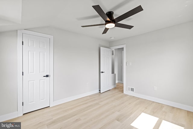 unfurnished bedroom with light wood-type flooring, lofted ceiling, and ceiling fan