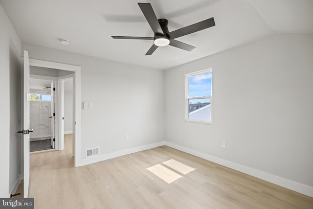 spare room with light hardwood / wood-style floors, vaulted ceiling, and ceiling fan