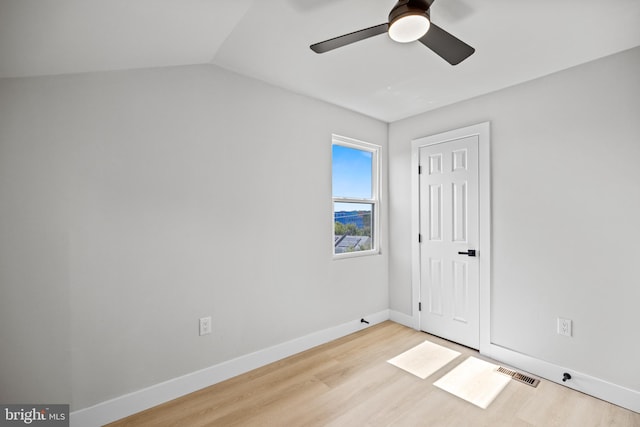 spare room with light wood-type flooring, lofted ceiling, and ceiling fan