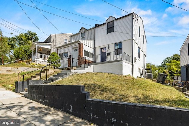 view of front facade with cooling unit and a front yard