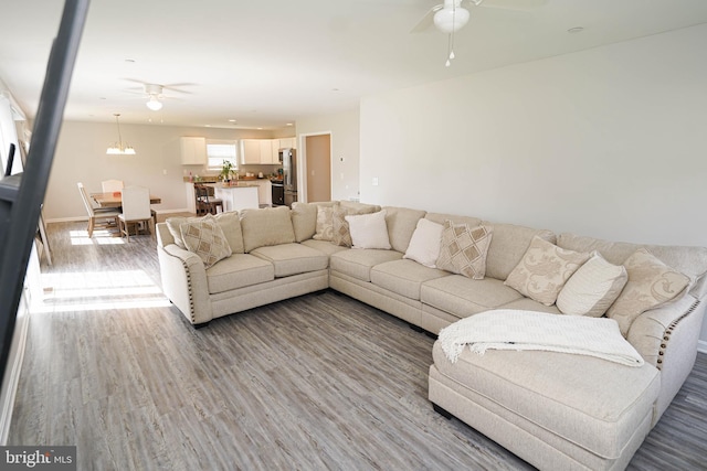 living room featuring ceiling fan and light hardwood / wood-style floors