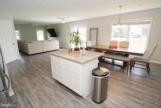 kitchen featuring hanging light fixtures, ceiling fan with notable chandelier, white cabinets, and dark wood-type flooring