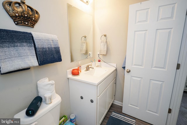 bathroom with vanity, toilet, and hardwood / wood-style floors