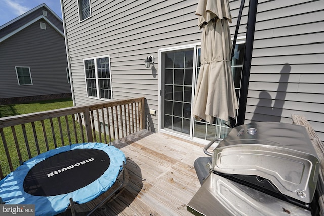 wooden deck featuring a yard and grilling area