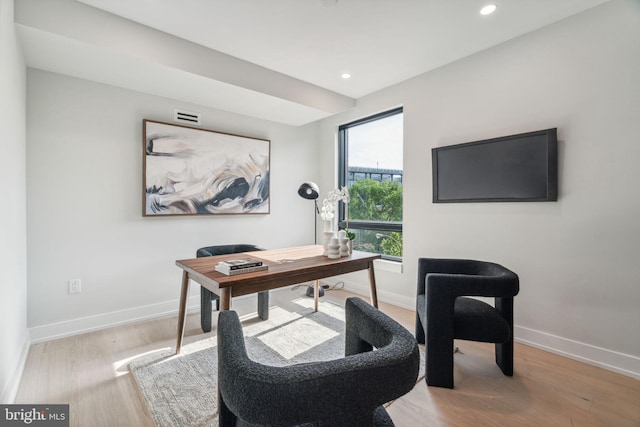 home office with light hardwood / wood-style flooring