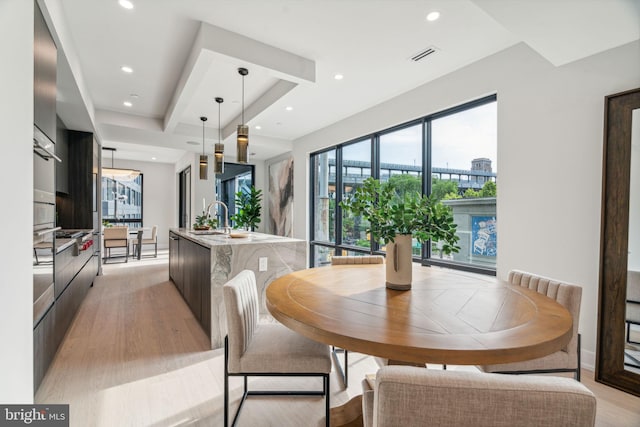 dining area featuring sink and light hardwood / wood-style flooring