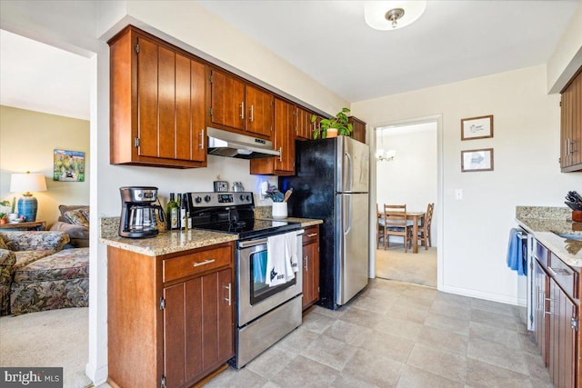 kitchen with light carpet, appliances with stainless steel finishes, and light stone counters