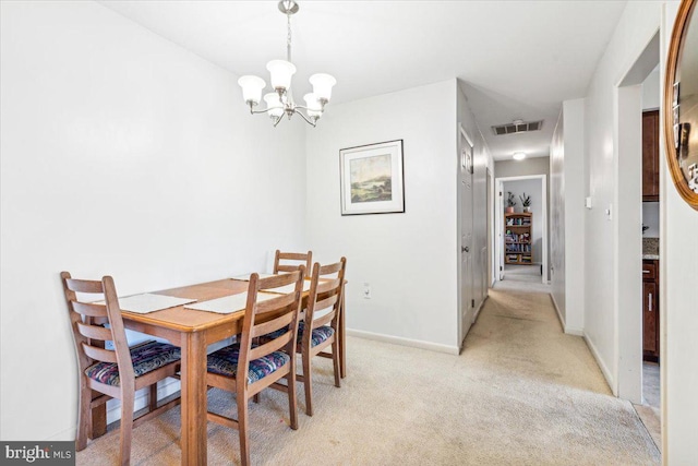 carpeted dining area featuring a chandelier