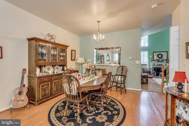 dining space with light hardwood / wood-style flooring and an inviting chandelier