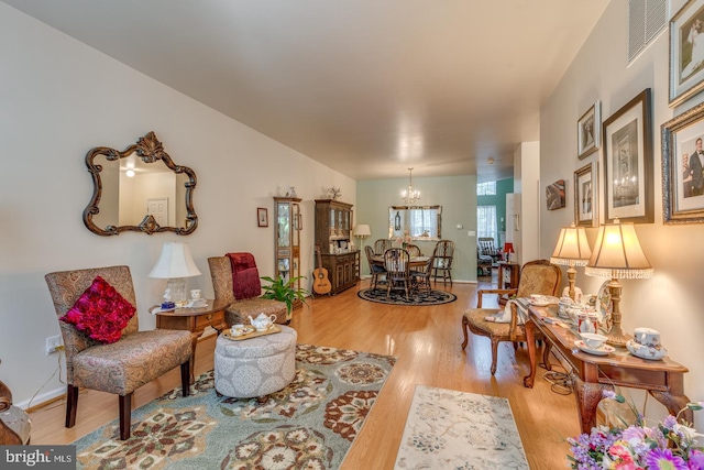 living room featuring light hardwood / wood-style flooring and a notable chandelier