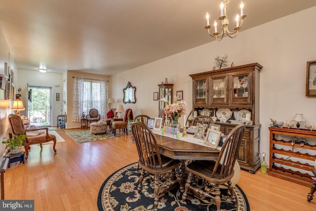 dining area featuring light wood-type flooring and a notable chandelier