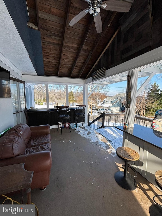 sunroom with vaulted ceiling with beams, ceiling fan, and wood ceiling