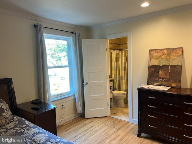 bedroom featuring ornamental molding, connected bathroom, and light hardwood / wood-style flooring