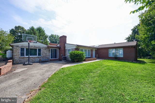 single story home with a front lawn and central air condition unit