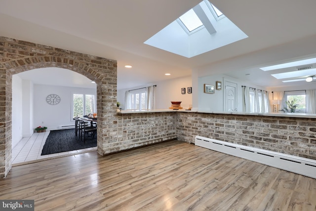 kitchen with a skylight, light hardwood / wood-style flooring, and a healthy amount of sunlight