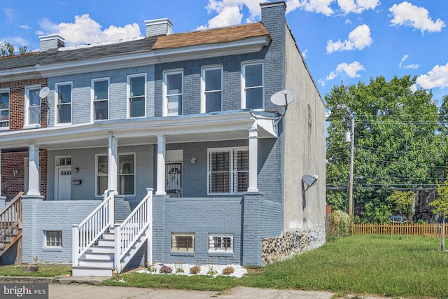 view of property featuring a porch and a front yard