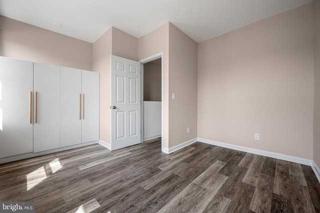 unfurnished bedroom featuring dark wood-type flooring and a closet