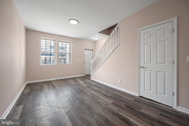 unfurnished room with dark wood-type flooring