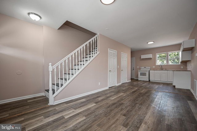 unfurnished living room with sink and dark wood-type flooring