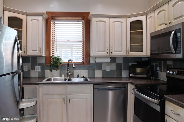 kitchen with white cabinets, stainless steel appliances, tasteful backsplash, and sink